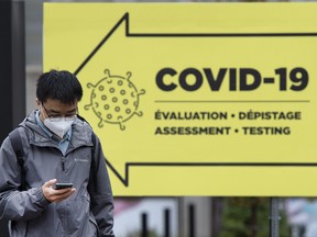 A man walks past a COVID-19 testing clinic in Montreal, Friday, Oct. 16, 2020.