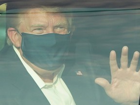 A car with US President Trump drives past supporters in a motorcade outside of Walter Reed Medical Center in Bethesda, Maryland on October 4, 2020.