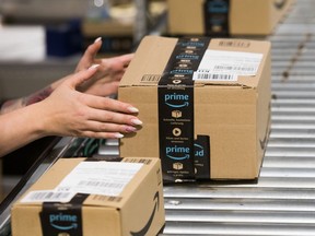 An employee takes a package from the conveyor belt at an Amazon.com Inc. fulfillment center in Kegworth, U.K., on Monday, Oct. 12, 2020.