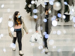 Masked shoppers walk in Bankers Hall which is decorated for Christmas on Thursday, November 26, 2020.