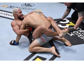 LAS VEGAS, NEVADA - NOVEMBER 21: In this handout image provided by UFC,  (L-R) Deiveson Figueiredo of Brazil submits Alex Perez in their flyweight championship bout during the UFC 255 event at UFC APEX on November 21, 2020 in Las Vegas, Nevada.