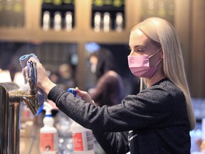 Bartender Kirstyn Streukens cleans her taps at Last Best Brewing on 11th Avenue S.W. in Calgary on Friday, Nov. 13. 2020.