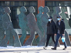 Masked pedestrians walk along 17th Avenue S.W. in Calgary on Sunday, Nov. 15, 2020.