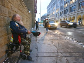 Dave "Red" Hackenschmidt, 67, panhandles at 7 Ave and 1 St SW in downtown Calgary during afternoon rush hour on Friday, November 20, 2020.