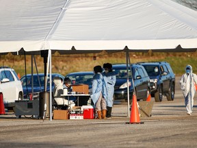 Medical personnel works on site of the drive-thru Illinois Department of Public Health COVID-19 mobile testing location at the Arlington International Racecourse in Arlington Heights, Illinois, on November 12, 2020.
