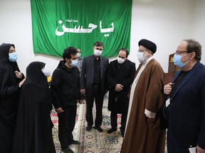 Iran's Judiciary Chief Ayatollah Ebrahim Raisi (2nd-R) pays respects to the body of slain scientist Mohsen Fakhrizadeh among his family, in the capital Tehran on November 28, 2020. - Mohsen Fakhrizadeh, dubbed by Israel as the "father" of Iran's nuclear programme, died on November 27 after being seriously wounded when assailants targeted his car and engaged in a gunfight with his bodyguards outside Tehran, according to Iran's defence ministry. The assassination comes less than two months before US President-elect Joe Biden is due to take office, after a tumultuous four years of hawkish foreign policy in the Middle East under President Donald Trump.