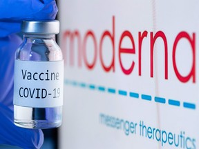 This file photo taken on Nov. 18, 2020 shows a bottle reading "Vaccine COVID-19" next to the Moderna biotech company logo.