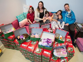 Michelle and Patrick Keogh sit with their four daughters from left; Sydney, Samara, Salem and Savannah with shoeboxes filled with school supplies, toys, clothing and hygiene items as part of the Samaritan's Purse Christmas Shoe Box campaign at their home on Monday, November 16, 2020. Salem had the idea for her family to pack 10,000 boxes on her 7th birthday, now six years later they are closing in on that goal having packed 1,200 boxes this year alone.