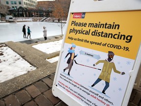 With public skating now open at Olympic Plaza on Wednesday, Nov. 18, 2020, a sign reminds skaters on the ice they need to be hockey stick length apart to avoid being too close to others.