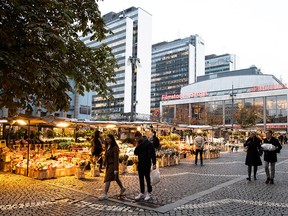 People walk past market stalls at Hotorget square, amid the outbreak of the coronavirus disease (COVID-19), in central Stockholm, Sweden October 30, 2020.