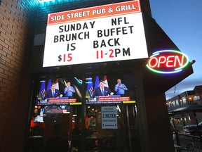 Patrons at Side Street Pub and Grill watch as Alberta Premier Jason Kenney places new restrictions to help fight the rise of COVID-19 in Calgary on Tuesday, Nov. 24, 2020.