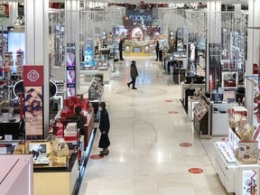 Customers wearing protective masks shop at Macy's store during Black Friday on November 27, 2020 in New York.