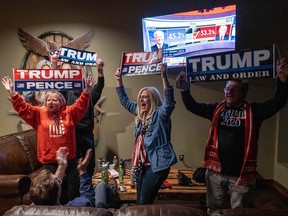 Donald Trump supporters celebrate as they watch Ohio being called for Trump at a Republican party at Huron Vally Guns in New Hudson, Mich., on Nov. 3, 2020.