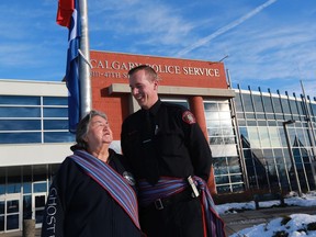 Metis elder Faye Fabel-Beazley and Const. Alan Chamberlain, an Indigenous liaison officer who is also Metis, pose after the raising of the Metis flag at Calgary Police Service headquarters on Monday, November 13, 2017. The Calgary Alliance for the Common Good is calling for more Indigenous liaison officers.