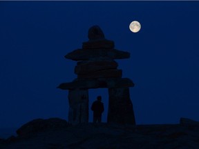 Cory McFarlane of Winnipeg checks out a giant Inukshuk in Rankin Inlet, Nunavut, Wednesday, Aug. 21, 2013. It's been just over two weeks since Nunavut declared its first case of COVID-19, but it's still unknown what exactly contributed to the rapid spread of the virus that's infected 84 people in the territory of about 39,000.