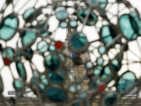 The dome of the Alberta Legislature is visible through the sculpture FireBrand Glass, in Edmonton Sunday Nov. 15, 2020.