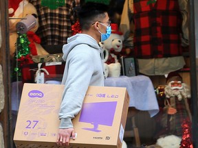 A shopper walks past a Christmas window display in downtown Calgary on Monday, Nov. 30, 2020.