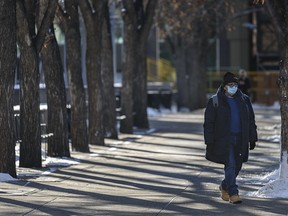 A masked pedestrian walks in downtown Calgary on Friday, Nov. 20, 2020.