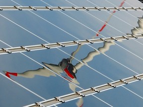 A power-generating wind turbine is reflected in solar panels on March 10, 2010.