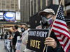 A man wearing a mask stands outside Madison Square Garden, which is used as a polling station, on the first day of early voting in Manhattan on Oct. 24, 2020.