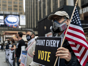 A man wearing a mask due to the COVID-19 pandemic stands outside Madison Square Garden, which is used as a polling station, on the first day of early voting in Manhattan, New York, October 24, 2020.