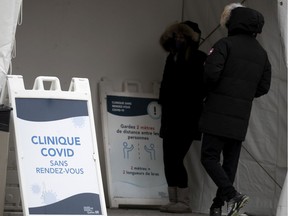 People wait to be called in to the Hotel Dieu COVID-19 testing site, in Montreal, on Thursday, Dec. 17, 2020.