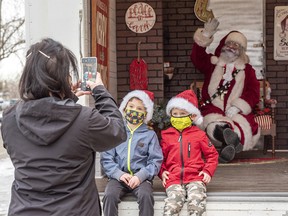 Seven-year-old James and his brother Benjamin, 4, visit Santa at his Santa Truck in the drive-thru at Crowfoot YMCA parking lot on Monday, Dec. 21, 2020.