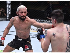 LAS VEGAS, NEVADA - DECEMBER 12:  (L-R) Deiveson Figueiredo of Brazil punches Brandon Moreno of Mexico in their flyweight championship bout during the UFC 256 event at UFC APEX on December 12, 2020 in Las Vegas, Nevada.