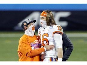 Clemson Tigers head coach Dabo Swinney stands with star quarterback Trevor Lawrence after defeating the Notre Dame Fighting Irish 34-10 in the ACC Championship game at Bank of America Stadium on Dec. 19 in Charlotte, N.C. (Photo by Jared C. Tilton/Getty Images)