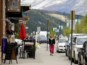 A woman walks down the main street in Jasper, Alberta on June 4, 2020.