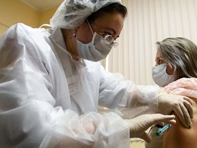 A nurse wearing a face mask proceeds to a vaccination against the coronavirus disease (COVID-19) by Sputnik V (Gam-COVID-Vac) vaccine at a clinic in Moscow on December 5, 2020, amid the ongoing coronavirus disease pandemic. - Russian President has told authorities to begin "large-scale" vaccinations among at-risk populations. The drugs should be made generally available to the Russian public in early 2021.
