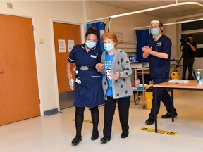 Nurse May Parsons (L) walks with Margaret Keenan (C), 90, at University Hospital in Coventry, central England, on December 9, 2020 as Keenan is prepared to revieve an injection and become the first person to get the Pfizer/BioNtech Covid-19 vaccine as Britain starts its biggest ever immunisation programme. - Britain on December 8 hailed a turning point in the fight against the coronavirus pandemic, as it begins the biggest vaccination programme in the country's history with a new Covid-19 jab. (Photo by Jacob King / POOL / AFP)