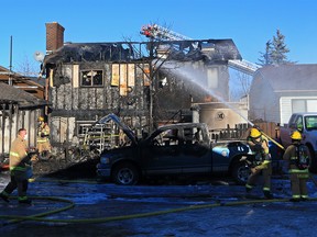 Calgary firefighters extinguish a house fire on Falshire Close N.E. on Sunday morning Sunday, Dec. 6, 2020. The home and garage were badly damaged in the blaze.