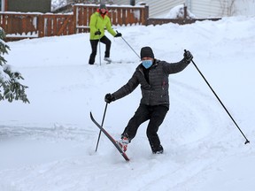 Dylann and Bill Golbeck enjoy powder turns as they skied through the trees down a slope in Confederation Park on Tuesday, Dec. 22, 2020. A heavy snowstorm blanketed the city overnight.