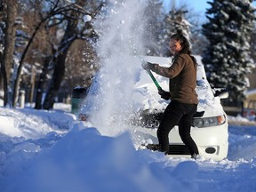 Norella King digs out her car in Marda Loop on Wednesday, Dec. 23, 2020. Calgarians were still dealing with snowy side roads the day after a heavy snowstorm hit the city.