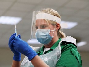 A St John's Ambulance volunteer holds a syringe during a coronavirus disease (COVID-19) vaccinator training course at the Princess Anne Training Centre in Derby, Britain November 28, 2020. REUTERS/Lee Smith