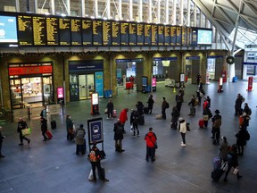 Travellers look at the information boards at King's Cross station, as EU countries impose a travel ban from the UK following the coronavirus disease outbreak, in London, Britain, Dec. 21, 2020.