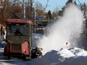 Snow removal crews are seen clearing snow on 5th Ave. NW. Monday, Dec. 28, 2020.