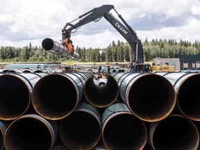 Pipe for the Trans Mountain pipeline is unloaded in Edson, Alta., on Tuesday June 18, 2019. The Canadian Energy Regulator is celebrating its co-operation with Indigenous communities and participation in the Indigenous Advisory and Monitoring Committee.