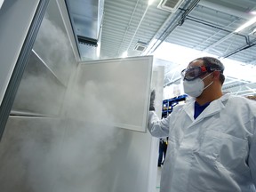 An employee opens an ultra-cold refrigerator filled with COVID-19 vaccines at a secret storage facility in the Rhein-Main area, Germany, Dec. 4, 2020.
