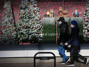 Masked Calgarians walk past a Christmas window display at the Holt Renfrew store on

Thursday, December 10, 2020.