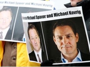 People hold signs calling for China to release Canadian detainees Michael Spavor and Michael Kovrig during an extradition hearing for Huawei Technologies Chief Financial Officer Meng Wanzhou at the B.C. Supreme Court in Vancouver, British Columbia, Canada, March 6, 2019.