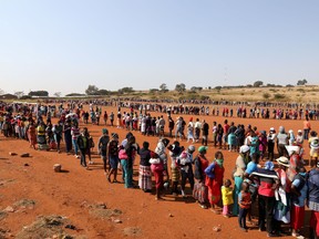 People stand in a queue to receive food aid, during the coronavirus disease (COVID-19) outbreak at the Itireleng informal settlement, near Laudium suburb in Pretoria, South Africa, May 20, 2020.