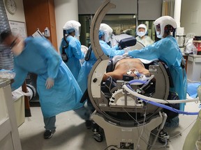 Nurses prepare a COVID-19 patient for RotoProne therapy in ICU at Sharp Grossmont Hospital on Dec. 14, 2020, in La Mesa, California.