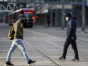 Pedestrians cross the street in downtown Calgary on Wednesday, Dec. 16, 2020.