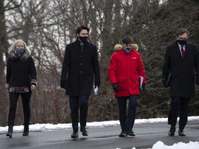 Infrastructure and Communities Minister Catherine McKenna, Prime Minister Justin Trudeau, Heritage Minister Steven Guilbeault and Environment and Climate Change Minister Jonathan Wilkinson walk to make an announcement on the government's updated climate change plan, in the Dominion Arboretum in Ottawa, on Friday, Dec. 11, 2020.