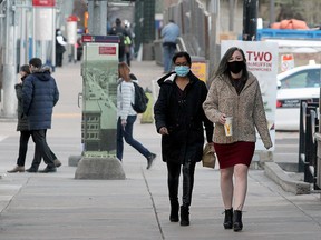 Women wearing masks walk downtown on Wednesday, Dec. 2, 2020.