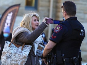 A protester and a Calgary police officer video each other during a protest against pandemic restrictions on Sunday, December 20, 2020. 

Gavin Young/Postmedia