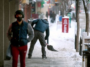 A man is seen shovelling snow along 10th Street N.W. on Saturday, Dec. 26, 2020.