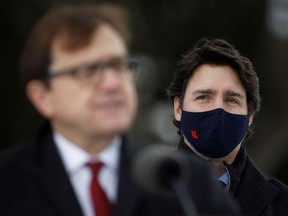 Prime Minister Justin Trudeau listens to Minister of the Environment and Climate Change Jonathan Wilkinson during a news conference Friday.